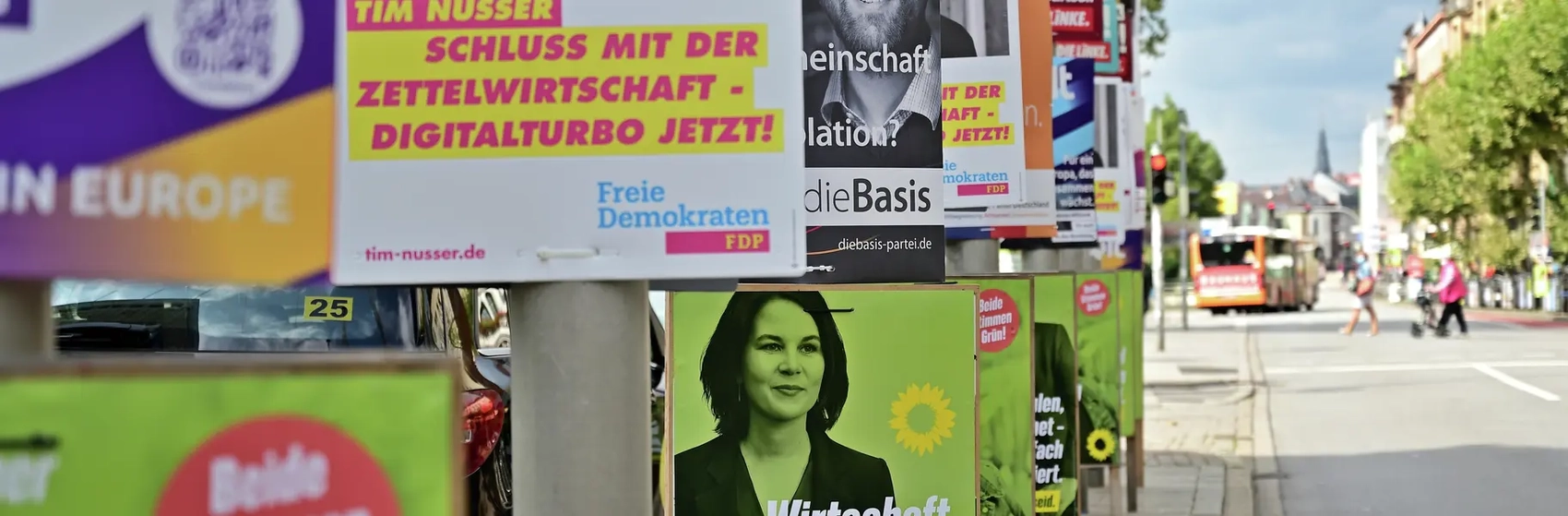 An einer Straße hängen ganz viele Wahlplakate.